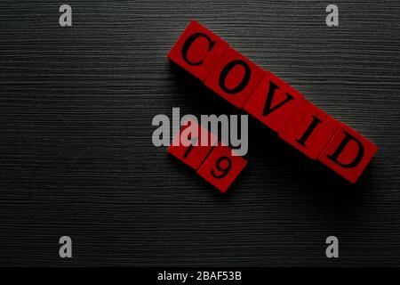 COVID-19 Name des Corona-Virus aus Wuhan Textwort auf drak-Holzhintergrund. Stockfoto