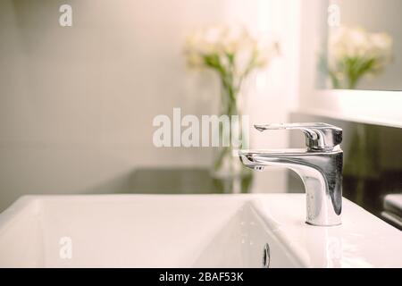 Badezimmer luxuriöses Waschbecken und Wasserhahn in der toilette zum Händewaschen mit Blumendekor Stockfoto