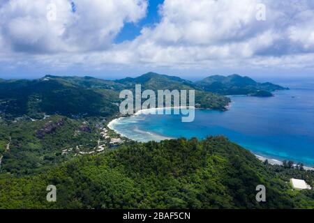 Panoramablick der Drohne auf die Küste von Mahe Island mit üppigen grünen Bergen, Bucht, Strand und Indischen Ozean, Seychellen Stockfoto