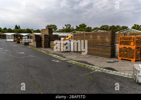 Standbau einer regionalen Messe, Zeltkonstruktion, Holzpfosten und Holzbretter für den Zeltboden auf dem Stapel, Zelte im Hintergrund, Alu Stockfoto