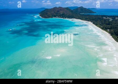 Panoramablick der Drohne auf den geschwungenen Strand von Anse Volbert Cote d'Or mit türkisfarbener Lagune, Praslin, Seychellen Stockfoto