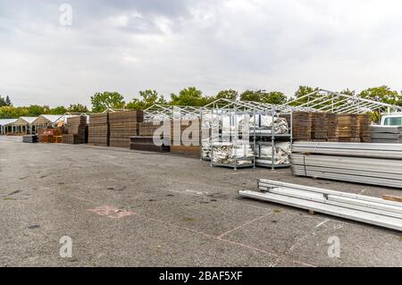 Standbau einer regionalen Messe, Zeltkonstruktion, Holzpfosten und Holzbretter für den Zeltboden auf dem Stapel, Zelte im Hintergrund, Alu Stockfoto