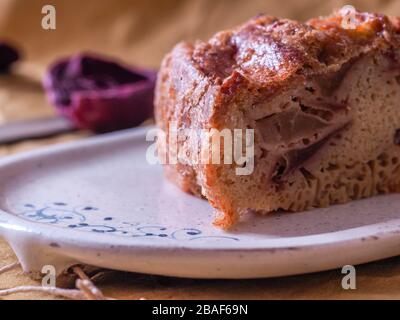 Ein Foto einer ganzen mehlapfel-pastete in Allu-Folie, auf einem dunkelrustikalen braunen Hintergrund mit Äpfeln und biologischen Eiern Foto Stockfoto