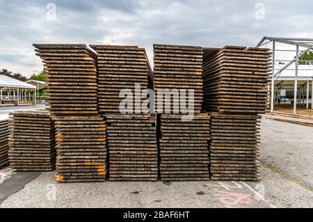 Standbau einer regionalen Messe, Zeltkonstruktion, Holzpfosten und Holzbretter für den Zeltboden auf dem Stapel, Zelte im Hintergrund, Alu Stockfoto