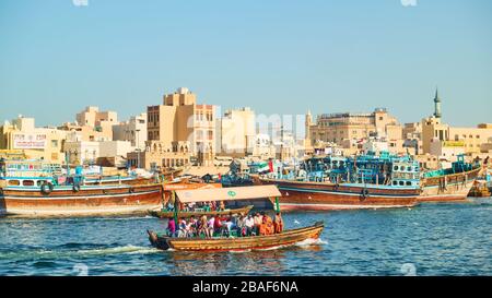 Dubai, VAE - 31. Januar 2020: Dhow-Boote an der Wharf und traditionelles ABRA-Boot mit Passanten am Creek im Deira Distrikt in Dubai, United Arab Stockfoto