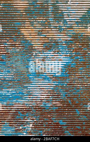 Abblätternde Farbe auf rostigem Wellmetall Stockfoto