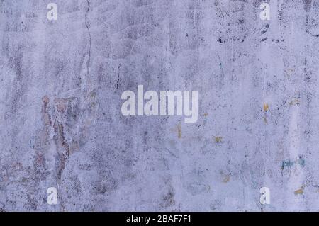 Verputzte Wand mit mehreren Lackschichten in verschiedenen Farben übermalt, die durch Verwitterung und Abrieb in unterschiedlichem Maße abgeschält sind, Stockfoto