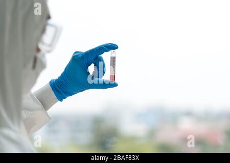 Epidemiologische Forscher in der Virus-Schutzkleidung untersuchen Blutproben von Patienten, die mit Covid-19 infiziert sind. Stockfoto