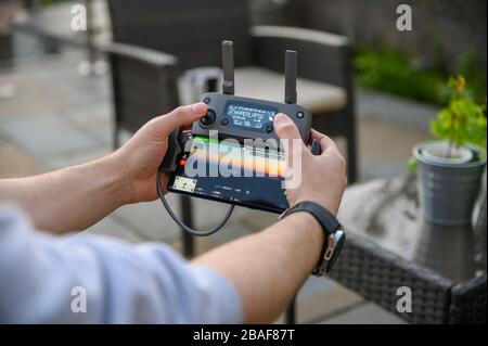 Abertillery, Gwent, südwales 27. märz 2020 - männliches halten von dji mavic Controller über das schauen schöner sunsnet .hyperlap Stockfoto