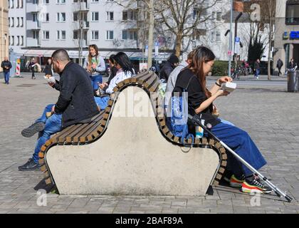 Menschen sitzen trotz Covid-19 dicht beieinander auf einer Bank Stockfoto
