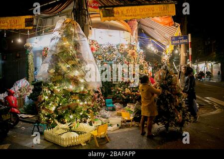 Weihnachtsbäume und Dekorationen, die an einer Ecke der Altstadt in Hanoi verkauft werden Stockfoto