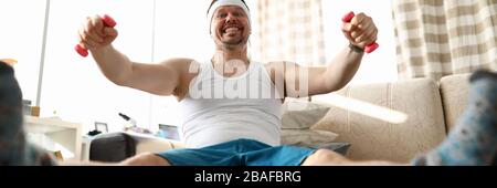 Lustiger lächelnder Mann, der auf dem Fit Ball sitzt und dabei arbeitet Stockfoto