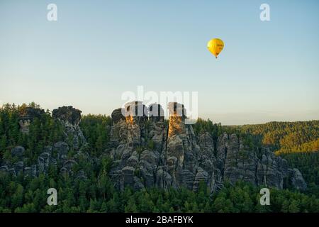 Heißluftballon über das Elbsandsteingebirge in der Nähe der Bastei in der Abendsonne, Nationalpark Sächsischen Schweiz, Land Sachsen, Deutschland Stockfoto