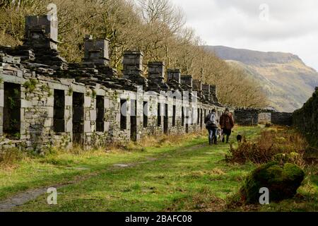 Anglesey Barracks - eine Reihe von Bergarbeiterhäusern in Dinorwig in Nordwales mit zwei Hundegängern Stockfoto
