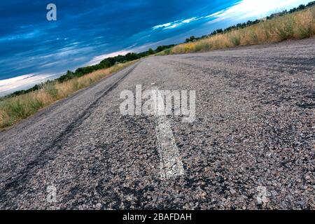 Freie Asphaltstraße auf Steppe vor Gewitter Stockfoto