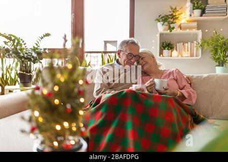 Senioren-Paar zu Weihnachten im Wohnzimmer zusammen Stockfoto