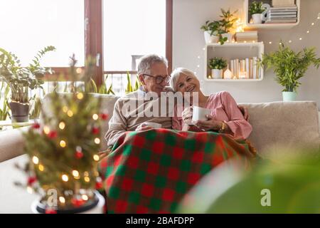 Senioren-Paar zu Weihnachten im Wohnzimmer zusammen Stockfoto