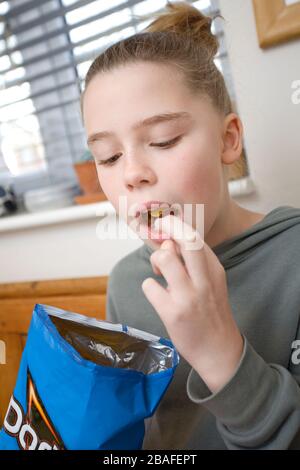 Junges Mädchen, das Dorito Chips isst Stockfoto