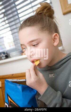 Junges Mädchen, das Dorito Chips isst Stockfoto