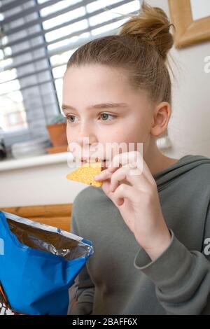 Junges Mädchen mit Dorito chip im Mund Stockfoto