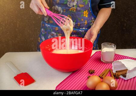 Backzutaten und Utensilien zum Kochen von Schwammkuchen. Backen Des Schwammkochs Verarbeiten. Frau, Die Den Teig Mixt. Stockfoto