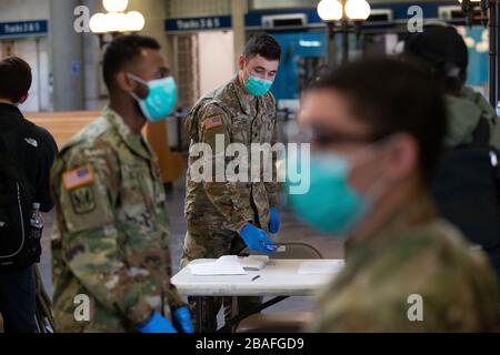 Providence, Vereinigte Staaten. März 2020. Mitglieder der Nationalgarde der Rhode Island Army bereiten sich darauf vor, Informationen von ankommenden Reisenden im Bahnhof Providence, Rhode Island, am Donnerstag, den 27. März 2020 zu erhalten. Die Nationalgarde wurde dazu gebracht, Informationen über Reisende, die in den Staat kommen, im Rahmen der Verfolgung der öffentlichen Gesundheit für COVID-19 zu erfassen. Auch Rhode Island Gouverneurin Gina Raimondo kündigte an, dass alle Besucher, die aus New York in den Bundesstaat kommen, 14 Tage lang selbst unter Quarantäne gestellt werden müssen. Foto von Matthew Healey/UPI Credit: UPI/Alamy Live News Stockfoto