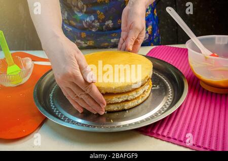 Backzutaten und Utensilien zum Kochen von Schwammkuchen. Backen Des Schwammkochs Verarbeiten. Frau bildet einen Kuchen. Stockfoto