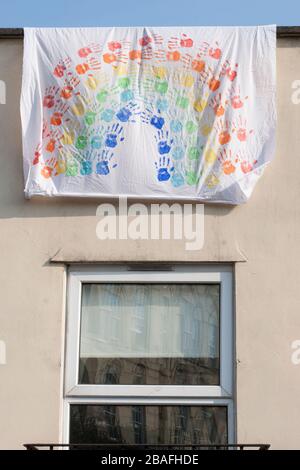 Bristol, Großbritannien. März 2020. Ein Regenbogen am Fenster einer Wohnung. Handgedruckt auf einem Blatt. Das Meme "Chase the Rainbow" bezieht sich auf die Corona-19-Pandemie. Stockfoto