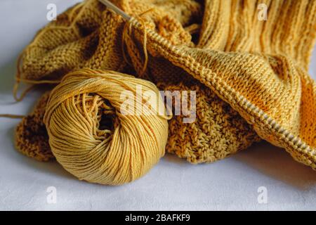 Gelbe Strickgarnkugel mit Nadeln Stockfoto