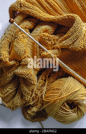 Gelbe Strickgarnkugel mit Nadeln Stockfoto