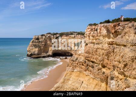 Ein Paar auf einer Klippe an der Küste gehen östlich von Alporchinhas, Algarve, Portugal Stockfoto