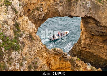 Lagos, Portugal - 4. März 2020: Touristen, die Ponta da Piedade auf einem Boot besuchen Stockfoto