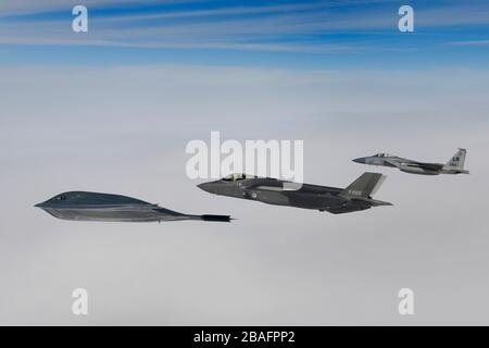 Ein Kampfflugzeug der Royal Netherlands Air Force F-35A Stealth-Kampfflugzeug und ein Kampfflugzeug der U.S. Air Force F-15C Eagle fliegen in Formation und eskortieren einen B-2A Spirit Bomber, der dem 509th Bomb Wing zugeordnet ist, während Luftoperationen zur Unterstützung der Bomber Task Force Europe 20./2. März 2020 über der Nordsee. Stockfoto