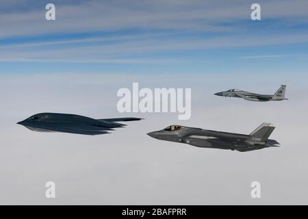 Ein Kampfflugzeug der Royal Netherlands Air Force F-35A Stealth-Kampfflugzeug und ein Kampfflugzeug der U.S. Air Force F-15C Eagle fliegen in Formation und eskortieren einen B-2A Spirit Bomber, der dem 509th Bomb Wing zugeordnet ist, während Luftoperationen zur Unterstützung der Bomber Task Force Europe 20./2. März 2020 über der Nordsee. Stockfoto