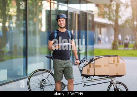 Fahrradbote, der eine Lieferung auf einem Frachtfahrrad macht Stockfoto