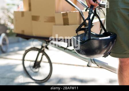 Fahrradbote, der eine Lieferung auf einem Frachtfahrrad macht Stockfoto