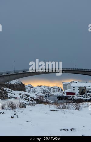 Winterszene mit Blick auf die Brücke, die das Dorf Henningsvaer verbindet, ein kleines Fischerdorf in der Nähe von Svolvaer, auf den Lofoten Inseln, Nordla Stockfoto