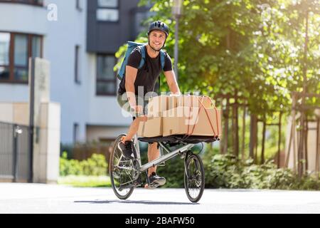 Fahrradbote, der eine Lieferung auf einem Frachtfahrrad macht Stockfoto