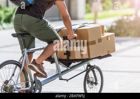 Fahrradbote, der eine Lieferung auf einem Frachtfahrrad macht Stockfoto