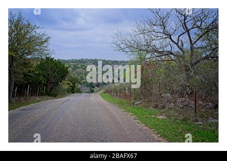 Texas Hill Country Landstraße mit Hügeln und bewölktem Himmel Stockfoto