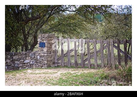 Wackeliges Holztor, Steinmauer, Schild, Texas Hill Country, Landstraße Stockfoto