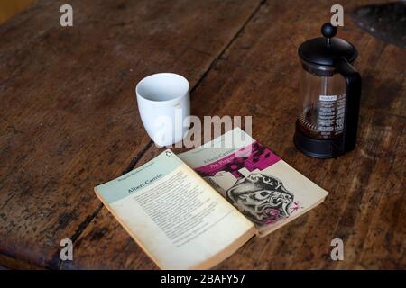 Hackney, London, England, Großbritannien. Corona Virus (Covid-19) Pandemie. Kopie von "The Plague" von Albert Camus und Kaffeekafetetiere. Stockfoto
