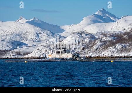 Blick auf eine Lachsfarm in einem Fjord mit schneebedeckten Bergen in der Nähe von Svolvaer, einer Fischerstadt auf den Lofoten Inseln, Nordland County, Norwegen. Stockfoto