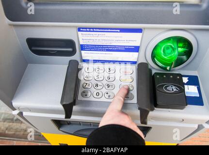 Hand der Mann- und PIN-Nummer am Geldautomaten im Frühjahr. Finanzen, Reisen, Kreditkarte. Lifestyle. Stockfoto