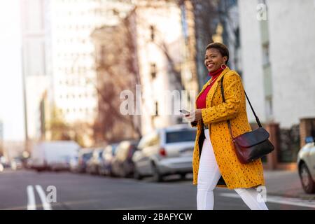 Junge Frau mit Smartphone in einem städtischen Stadtgebiet Stockfoto