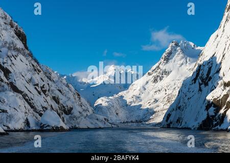 Der schneebedeckte Trollfjord im Winter auf Austvag Island auf den Lofoten Islands, Nordland County, Norwegen. Stockfoto