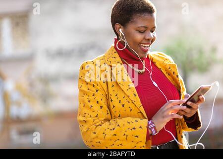 Junge Frau mit Smartphone in einem städtischen Stadtgebiet Stockfoto