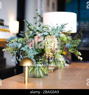 Florale Tischkulisse an der Bar in einem stilvollen modernen Scandi Restaurant Stockfoto