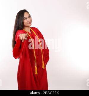 Ein junger Absolvent zeigt ihren Finger auf die Kamera. Stockfoto