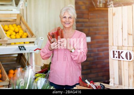 Frau, die in einem kleinen Lebensmittelgeschäft einkauft Stockfoto